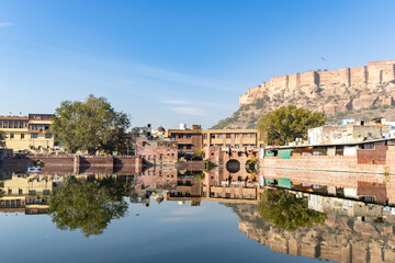 pristine calm lake with reflection of historical mehrangarh fort and houses around at morning
