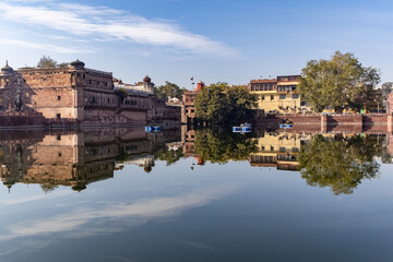 pristine calm lake with water reflection of vintage architecture around at morning
