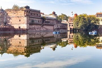 pristine calm lake with water reflection of vintage architecture around at morning
