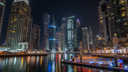 Fototapeta premium Dubai marina bay with yachts an boats night timelapse hyperlapse