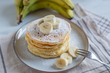 A stack of oatmeal banana pancakes with slices of fresh bananas
