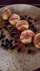 Potato dumplings with chocolate and blueberries served on plate in slovakia strbske pleso, high tatras