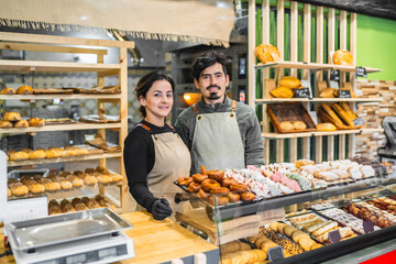 Bakers posing at the counter of their bakery shop