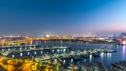 Obraz premium Dubai creek landscape day to night timelapse with boats and ship near waterfront