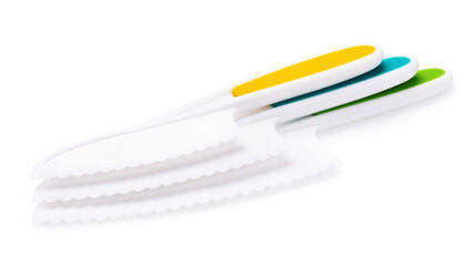Three children's plastic knives lying on each other, isolated on white background