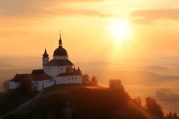 Obraz premium Sunset casts a golden glow over the historic church on the hilltop in a serene landscape