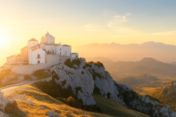 Sunset view of a historic white chapel perched on a rocky hilltop overlooking a vast landscape