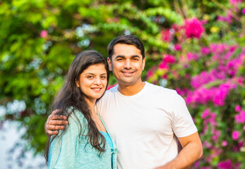 Obraz premium Young Indian couple sharing a joyful morning nature walk, smiling, pointing, and bonding together