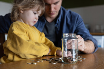 Father and daughter Counting Coins Together on Dining Table