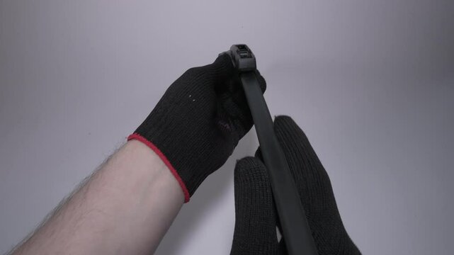 Hands Gripping a Windshield Wiper Blade for Installation or Replacement