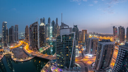 Obraz premium Aerial view of Dubai Marina residential and office skyscrapers with waterfront night to day timelapse