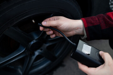 man driver hand inflating tires of vehicle, removing tire valve nitrogen cap for checking air...