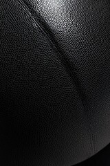 Close-up of textured black leather surface with subtle seam.