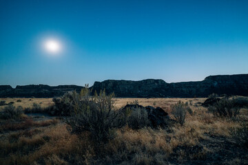 Moonlit Desert Landscape at Ancient Lakes WA – Serene Nighttime View of Rugged Cliffs and Sagebrush Under a Glowing Sky