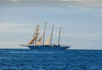 Tall ship with 4 masts on the sea at sunset