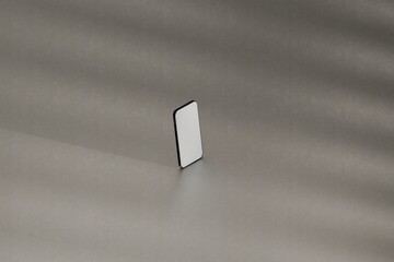 Mockup smartphone on grey studio floor. Hit by sunlight. Use as template for UX designs, websites, ads, and more