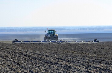 Spring's first agricultural landscapes. Agricultural workers went out into the field to prepare arable land for sowing. A trailing harrow closes the soil to preserve moisture for plants