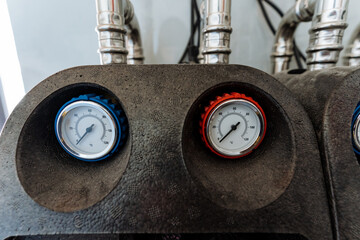 Here is a detailed closeup view featuring two pressure gauges that are mounted on a machine,...