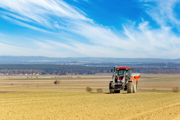 Obraz premium Tractor in a field of the early spring time agricultural activities.