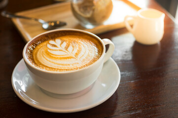 Hot latte coffee cup on wooden table.