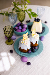 Holiday laid table for Easter with Easter cakes with white chocolate rabbit figurines, painted eggs and tradition Russian Easter dish called Easter made of cottage cheese