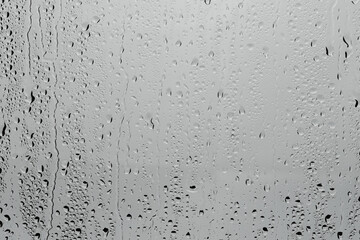 Water drops on light grey glass surface, top view
