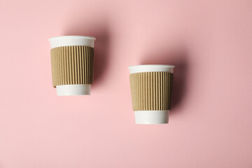 Paper cups on pink background, flat lay. Mockup for design