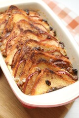 Delicious bread pudding in baking dish on table, closeup