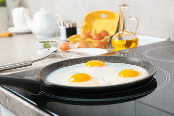 Cooking tasty eggs on frying pan in kitchen, closeup