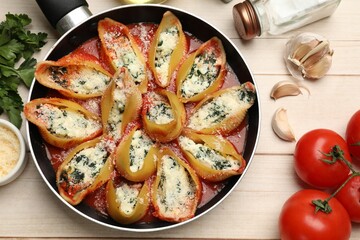 Delicious shell pasta stuffed with ricotta and spinach served on white wooden table, flat lay