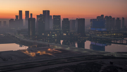 Abu Dhabi city skyline with skyscrapers before sunrise from above night to day timelapse