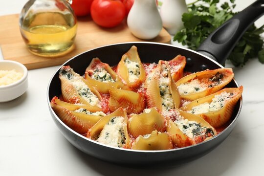 Delicious shell pasta stuffed with ricotta and spinach served on white table, closeup