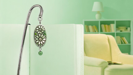 Metal bookmark with pressed flowers and dangling charm in journal