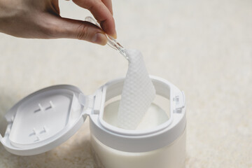 Woman takes toner pads for face. Clarifying tissues for clogged pores. Moisturizing effect with...