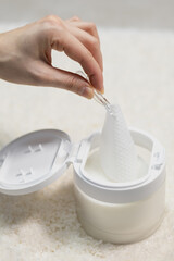 Vertical photo of Woman takes toner pads for face. Clarifying tissues for clogged pores....