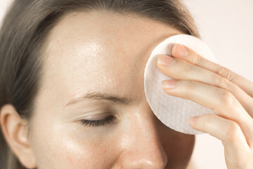 Woman wipes forehead with toner pads. Clarifying tissues for clogged pores. Moisturizing effect...