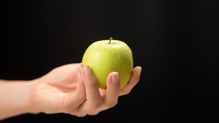 Fresh green apple in hand studio setting food minimalist design close-up view healthy eating concept