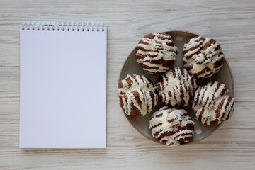 Homemade Profiteroles with Coconut Cream on a Plate, Blank Notepad, top view.