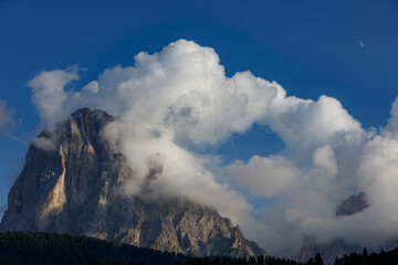 Majestic Dolomites landscape with clouds surrounding the peaks near Seceda, Sankt Christina, and...