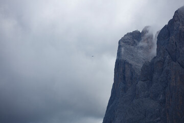 Cloudy Dolomites landscape near Seceda and Sankt Ulrich features a towering mountain with mist and low visibility conditions