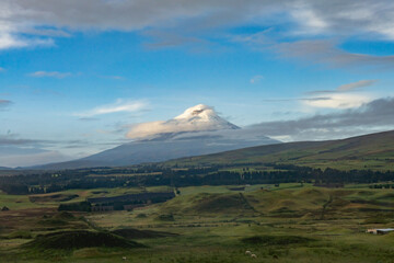 Clouds blowing over the glacier covered peak of Cotopaxi Volcano, seen from a nearby lodge, Ecuador