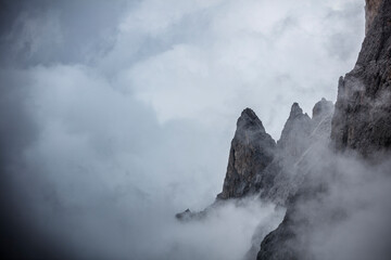 Dramatic skies and mist envelop Sassolungo in the Dolomites during a serene morning