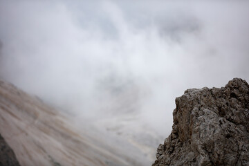 Dramatic clouds and mist enveloping Sassolungo in the Dolomites during early morning hours