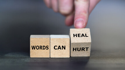 Hand turns cube and changes the expression 'words can hurt' to 'words can heal'.