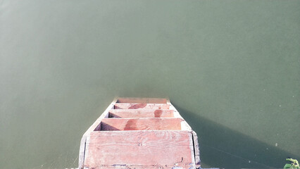 A well-built wooden ladder descends into tranquil green water, surrounded by a peaceful natural...
