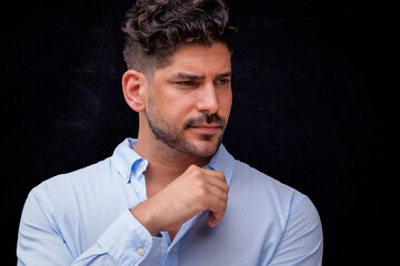 Portrait of a handsome man looking thoughtfully against dark background