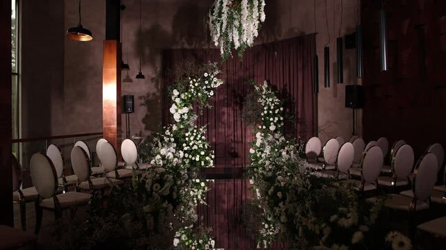 arch for the ceremony made of white flowers in the room at the wedding