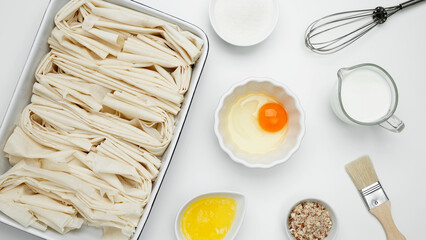 Crinkle Cake baking, filo dough in a baking dish near milk, eggs, butter, butter, sugar