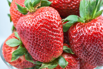A clear glass bowl filled with fresh, plump strawberries
