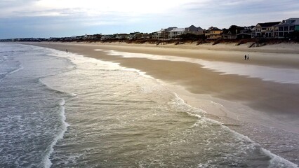 Fototapeta premium Peaceful quiet beach with gentle ocean waves and surf during the offseason at Litchfield Beach, SC low country part of the Grand Strand family destinations